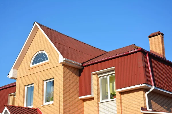 Exterior del techo ático con tejas de asfalto y sistema de canalón de lluvia de plástico. Construcción de techos. Tipo de techo de la casa de Mansard . — Foto de Stock