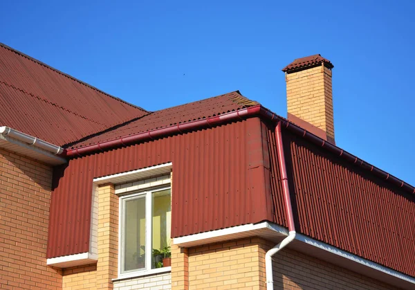 Techos tipo casa Mansard. Exterior del techo ático con tejas de asfalto y sistema de canalón de lluvia de plástico . — Foto de Stock