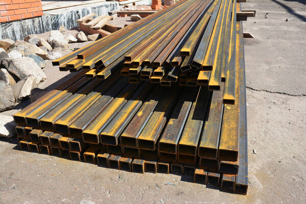 Rust steel channel bunch on house construction site outdoor. Steel beams for roofing. 