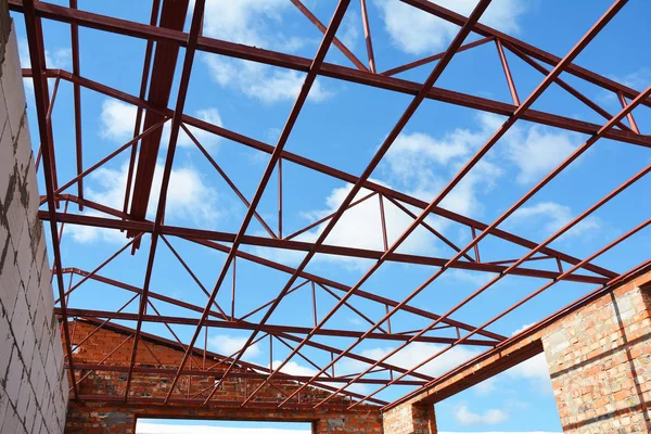 Steel roof trusses details with clouds sky background. Steel roof trusses sitting on concrete pole view from inside