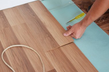 Adam yeni lamine ahşap döşeme yükleme. Ahşap Laminat parke yükleme. Adım adım.