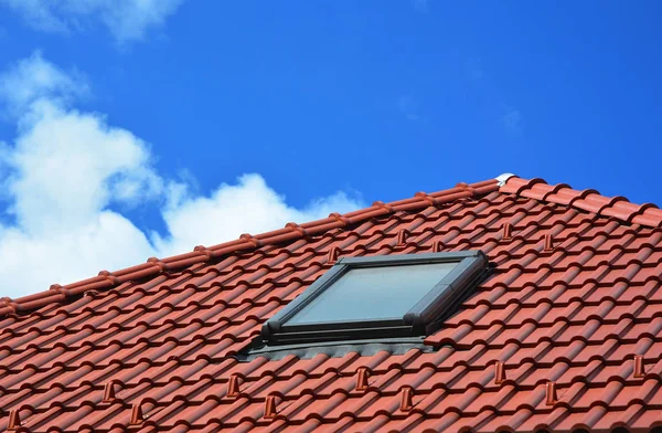 Dakraam op rode keramische tegels huis dak. Dakramen, dakvensters en zon Tunnels. — Stockfoto