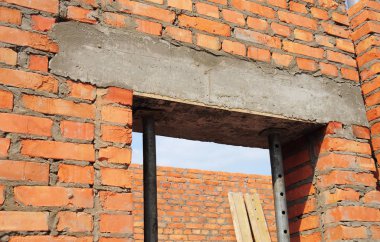 Pencere, beton kapı lentosu üzerinde demir çubuk ile tuğla bitmemiş ev yapımı.