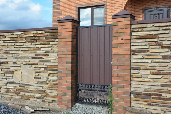 Instalación de valla de piedra con puerta metálica — Foto de Stock