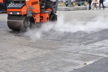 Yol onarım, Kompaktör asfalt bırakır. Roadworks yeni bir Asfalt döşeme üzerinde. Kaldırım ve yeni asfalt yama yöntemi açık havada döşeme tamir.