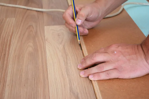 Man laying laminate flooring. Man laying laminate flooring.