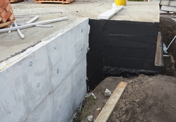 Waterproofing foundation bitumen and insulation with polystyrene foam boards for House Energy Saving. Damp proofing Coatings.Waterproofing house foundation with spray on tar.