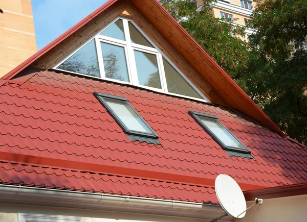 Moderne Dachfenster mit Oberlichtern und Sonnentunneln. moderner Hausbau mit Metalldach, Regenrinnensystem und Dachschutz vor Schneebrettern, Oberlichtern. — Stockfoto