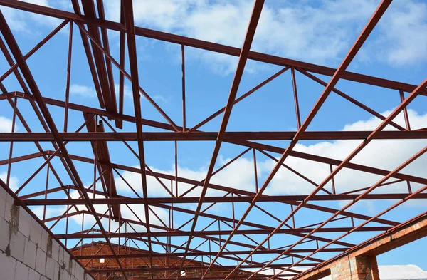 New Steel roof trusses details with clouds sky background. Industrial roofing.