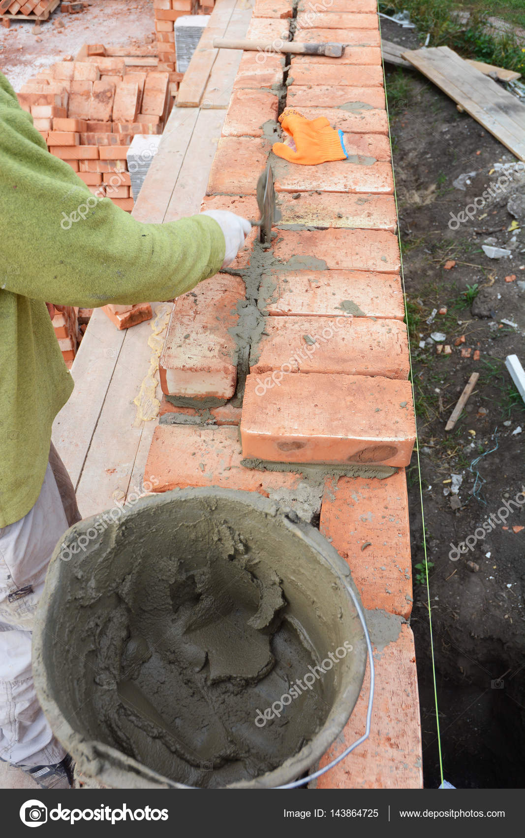 Bricklaying, Brickwork.Bricklayer worker installing red blocks and