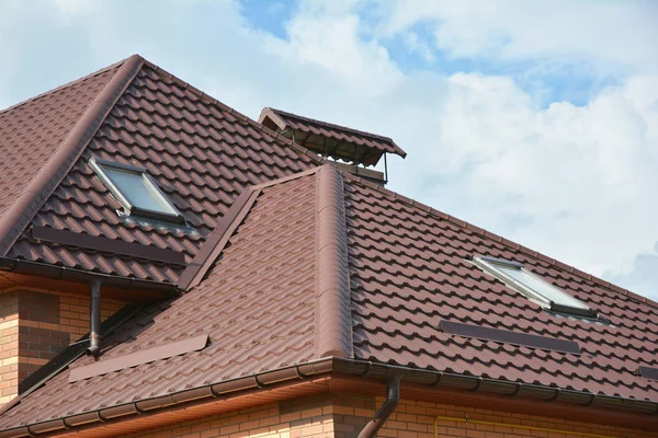 Moderne Hausdachkonstruktion mit Dachfenster, Regenrinnensystem, Dachfenster, Dachaußenseite. mehrstöckiges Dach mit Dachfenster. Baugebiet Dachabdichtung. — Stockfoto