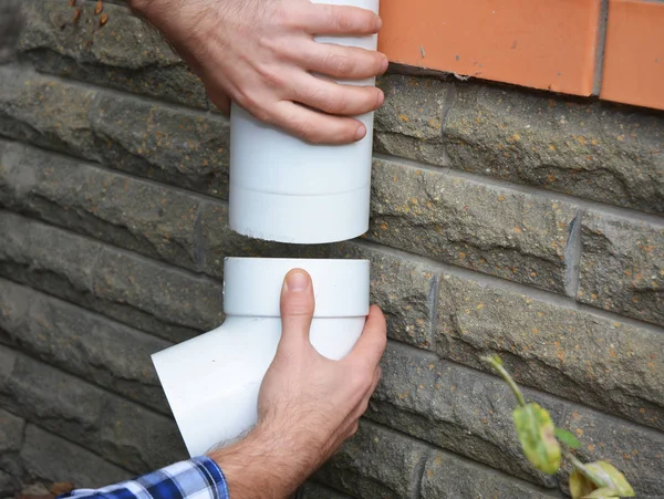 Man installing plastic rain gutter system pipeline. Guttering, Gutters, Plastic Guttering, Guttering & Drainage by Handyman hands. Guttering Down pipe Fittings. — Stock Photo, Image