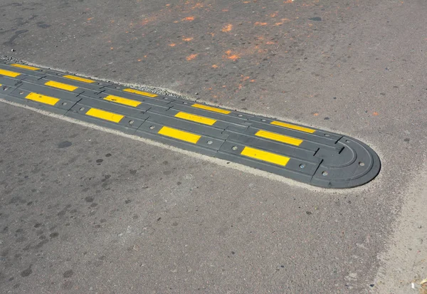 Traffic safety speed bump on an asphalt road. Speed bumps (or speed breakers).