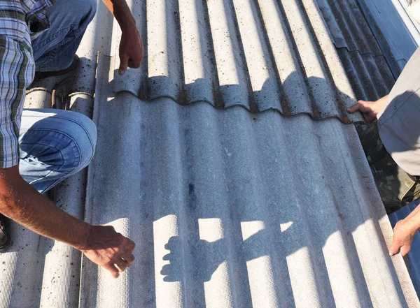 Roofer Reparación y reemplazo de asbesto peligroso Azulejos de techo viejo . — Foto de Stock