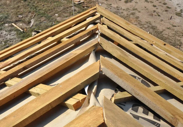 Ház tető sarok tető építése. Telepítse a ház tető fából készült Rácsos tartók és szigetelő membrán. — Stock Fotó