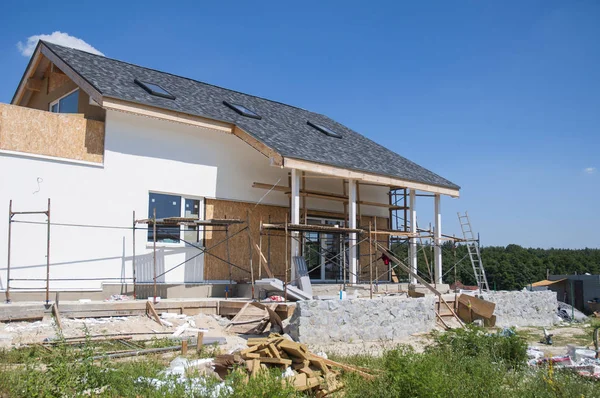 Rénover et réparer le mur de façade de la maison résidentielle avec stuc, isolation, plâtre, mur de peinture. Maison Construction avec toit en bardeaux d'asphalte, puits de lumière, terrasse patio. Construction de maisons modernes — Photo