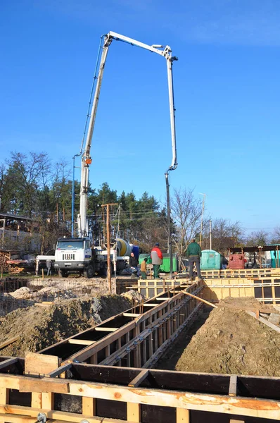 Kiev - Ukraina, juni - 11, 2017: Bygga upp en grund. Entreprenörer att göra en betongplatta, husgrund med bil med pump tube. Hälla en betongplatta längs grunden — Stockfoto