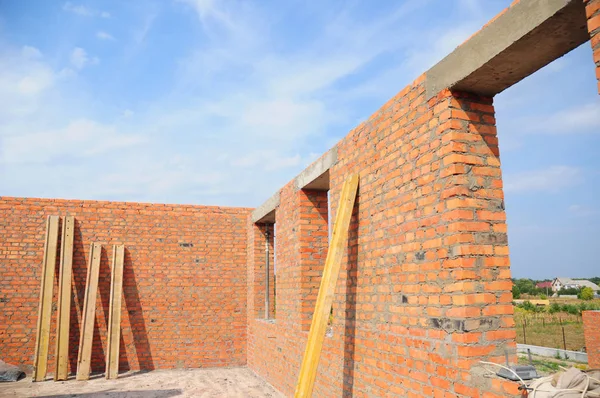 Interior de uma casa de tijolo vermelho inacabado em construção. Closeup na construção do buraco das janelas com verga de concreto . — Fotografia de Stock