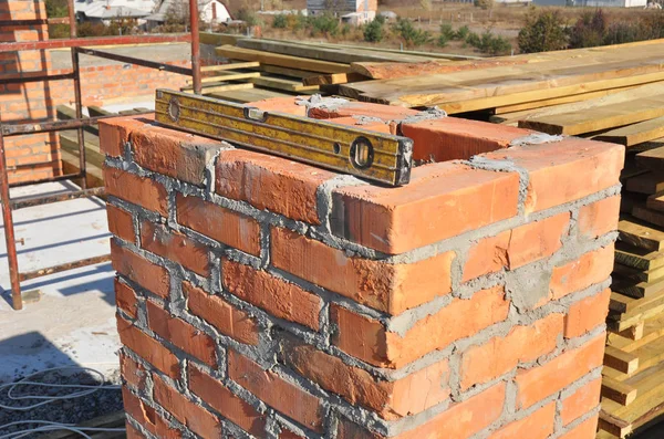 Costruire camino in mattoni nel tetto di costruzione casa incompiuta . — Foto Stock
