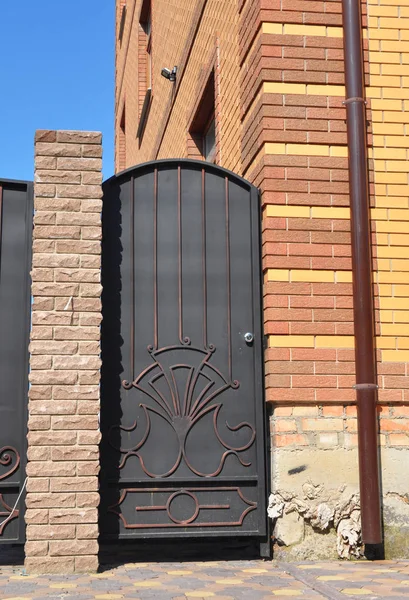 Instalação de cerca de tijolo com porta de metal e portão — Fotografia de Stock