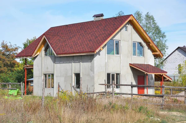 Reparación de techo de tejas de asfalto. Trabajos de Aislamiento Térmico y Pintura de Fachadas durante Renovaciones Exteriores. Casa sin terminar con construcción de techos con asfalto instalación de tejas al aire libre . — Foto de Stock