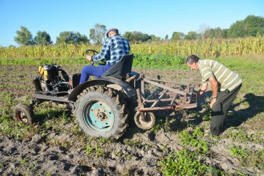 Kiev - Ukrayna, Nisan - 20, 2017: Çiftçi üzerinde eski çiftçilik el yapımı traktör. Rustik çiftçi traktör.