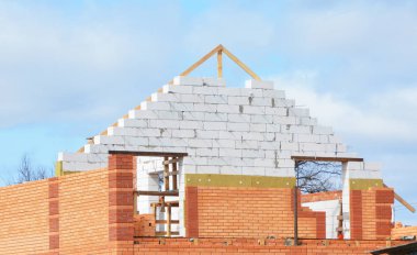 Attic inşaat mineralyün izolasyon ev. Bina izolasyon ile bitmemiş ev. Tuğla duvar ve ahşap kirişleri ve çatı onarımı ile tavan arası izolasyon. 