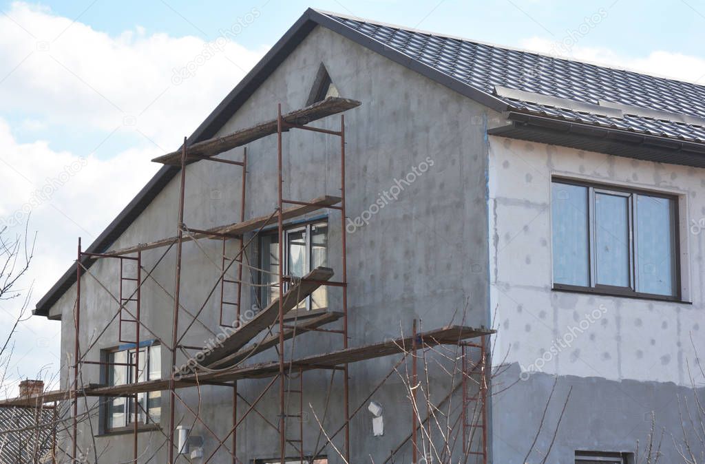 Painting, Plastering, Stucco  and insulate Exterior House Wall. Facade Thermal Insulation and Painting Wall  Repair Works During Exterior Renovations. Wall Insulation and Repair. 
