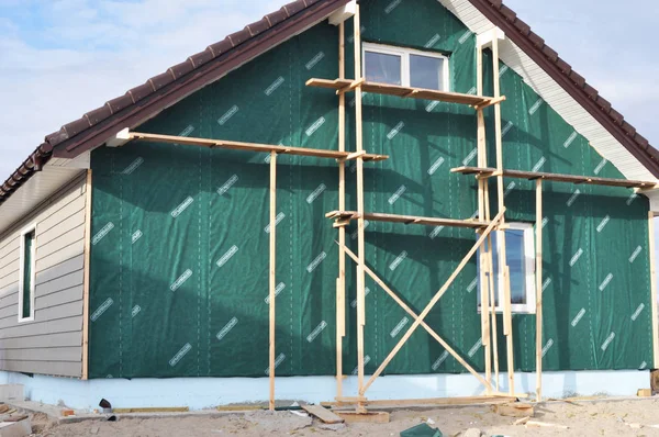 KIEV, UKRAINE - SEPTEMBER, 15, 2017:  Building, Repair, Remodeling House with Plastic Siding and Insulation Membrane, Mineral Wool.Foundation insulation with styrofoam. Installing Rigid Foam Insulation. — Stock Photo, Image