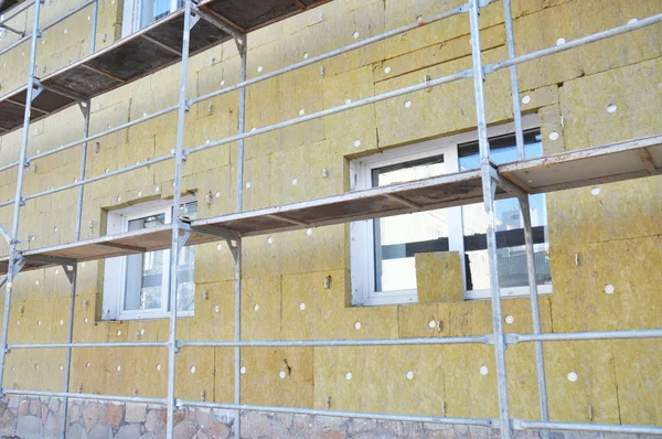 Εγκατάσταση μόνωση πετροβάμβακα ροκ. Ενεργειακή αποδοτικότητα τοίχο ανακαίνιση κατοικίας για εξοικονόμηση ενέργειας. Μόνωση θερμότητας τοίχων εξωτερικά το σπίτι με ορυκτό μαλλί, κτίριο υπό κατασκευή. — Φωτογραφία Αρχείου