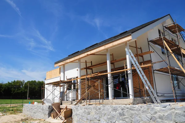 Renovar y reparar la pared de fachada de la casa residencial con aislamiento de lana mineral, yeso, pared de pintura al aire libre. Remodelación Casa Construcción con techo de tejas de asfalto. Renovación de casas . — Foto de Stock