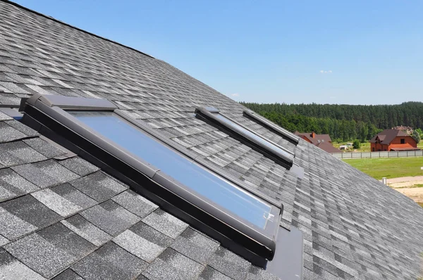 Attic skylight. Asphalt Shingles House Roofing Construction with Attic Roof windows, skylights waterproofing. — Stock Photo, Image