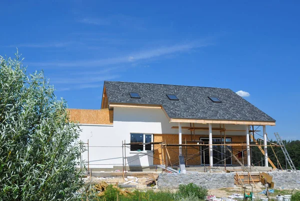 Rénover, Remodeler et réparer le mur de façade de la maison résidentielle avec isolation en laine minérale, mur de peinture. Maison Construction avec toit en bardeaux d'asphalte, puits de lumière, terrasse patio. puits de lumière grenier . — Photo