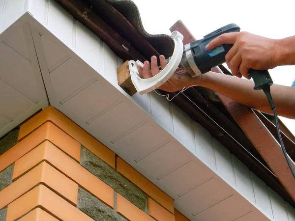 Instalowanie systemu rynnowego posiadacz deszczu na dachu. — Zdjęcie stockowe