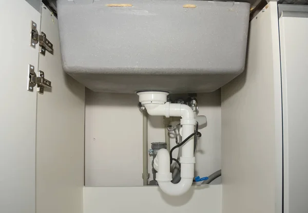 Fermer sur l'installation d'évier de cuisine en céramique avec tuyaux de vidange d'évier plomberie . — Photo