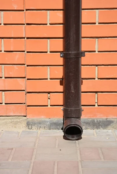 Желоб на крыше, пластиковый держатель и трубопровод Downspout без дренажной отверстия на тротуаре . — стоковое фото