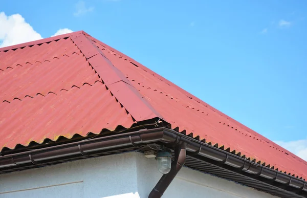 Close-up em casa de construção de coberturas vermelhas com sistema de calha de telhado . — Fotografia de Stock