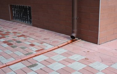 Çatı oluk downspout boru drenaj kaldırım ile. Yağmur oluk boru hattı drenajı.