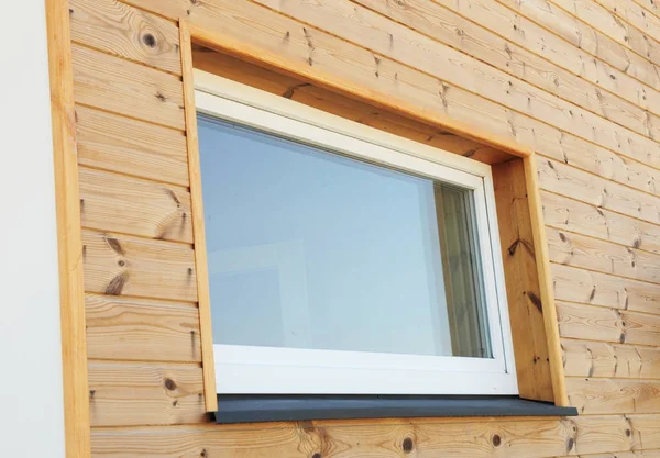 Ventana plástica del PVC en la nueva pared pasiva moderna de la fachada de madera de la casa. Las ventanas de PVC son el número uno en la eficiencia energética de la casa . — Foto de Stock