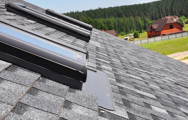 Primer plano en la reparación de la ventana del tragaluz del ático con membrana impermeabilizante en el techo de tejas de asfalto. Construcción de techos . —  Fotos de Stock