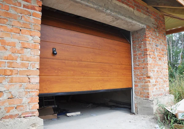 Встановлення гаражних дверей в будівництві нового цегляного будинку . — стокове фото