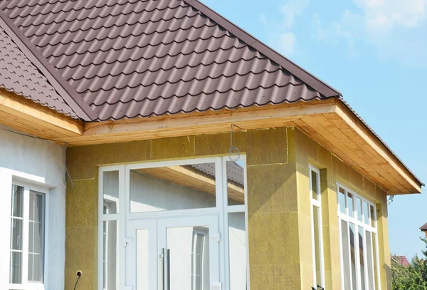 Установите металлическую крышу и каменную стену с незавершенными софитами и фасциальными досками. Утеплитель . — стоковое фото