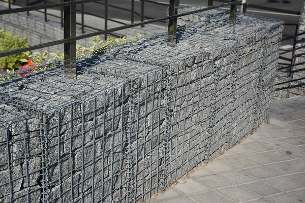 Moderní gabionový plot s kameny v drátěné mřížky. Pletivo drátěné gabionové oplocení s přírodními kameny. — Stock fotografie