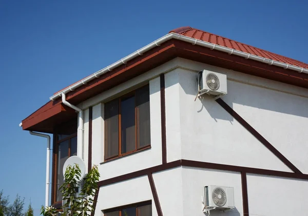 Red clay tiled house roof with plastic roof gutter.