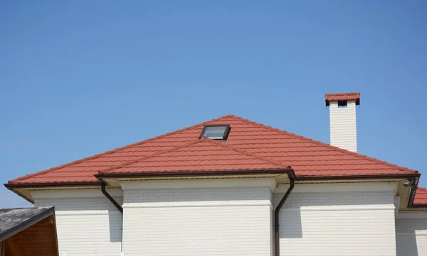 Red tiled roof with skylight window and rain gutter pipeline system.