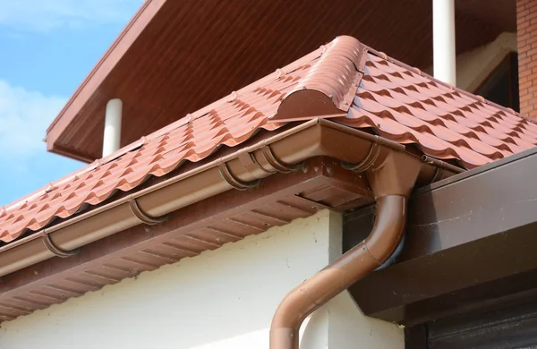 Κλείστε επάνω σε οροφή υδρορροών κάτοχος και guttering downspout σωλήνα με πηλό κεραμίδια στεγών. Εγκατάσταση υδρορροή βροχή. — Φωτογραφία Αρχείου