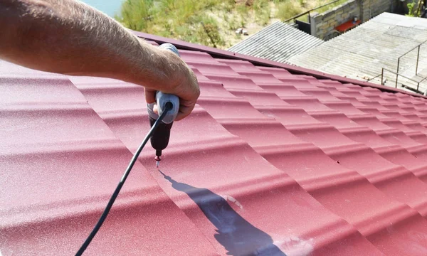 Roofing contractor installing metal roof tile for roof repair after hurricane damage. — Stock Photo, Image