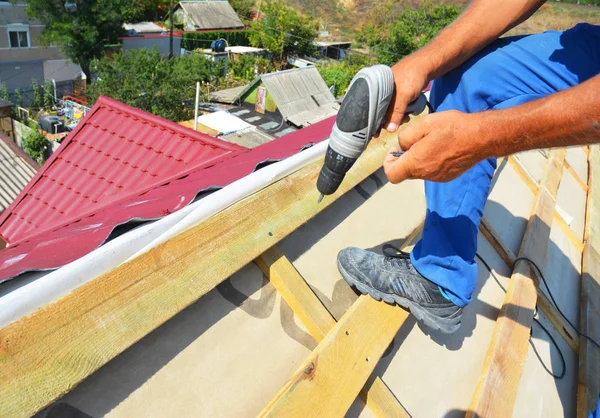 Dachdecker, der Metalldachziegel für die Dachreparatur nach Hurrikan-Schäden einbaut. Dachdecker reparieren Dach und Dämmung. — Stockfoto