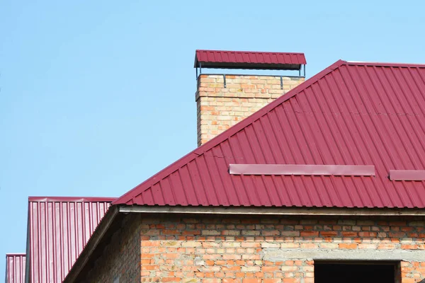 Metal roofing construction with brick wall and brick chimney. — Stock Photo, Image