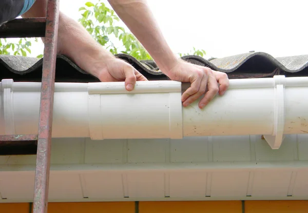 Entrepreneur installant un pipeline de gouttière de toit en plastique . — Photo